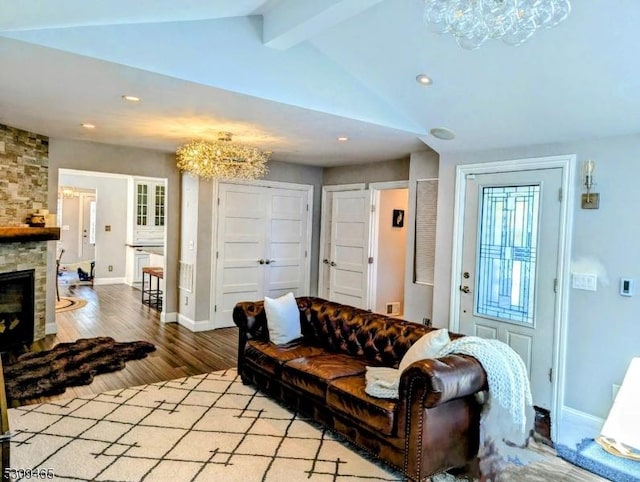 living room with lofted ceiling with beams, a fireplace, and light hardwood / wood-style floors