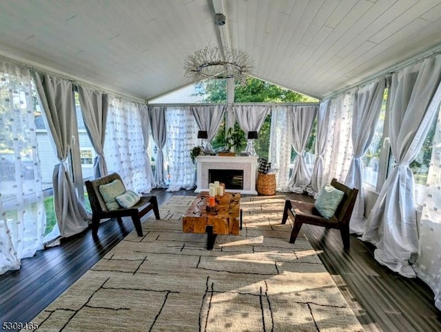 sunroom / solarium with lofted ceiling, exterior fireplace, and wooden ceiling