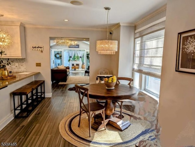 dining room featuring dark wood-type flooring, crown molding, and a chandelier