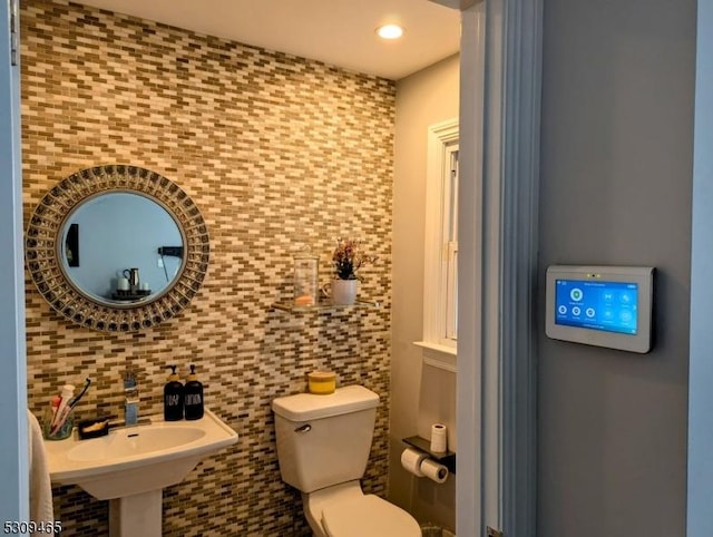 bathroom featuring sink, tile walls, decorative backsplash, and toilet