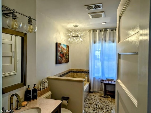 bathroom featuring vanity, a washtub, and toilet