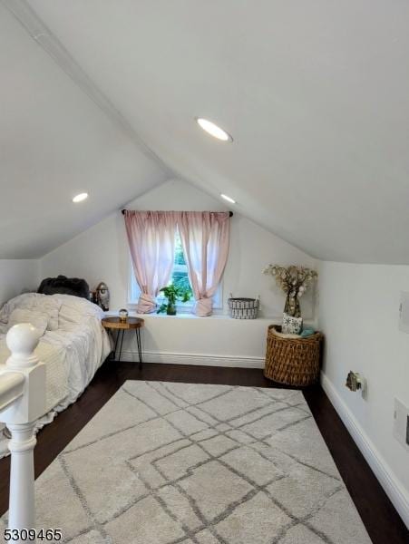 bedroom featuring dark wood-type flooring and vaulted ceiling