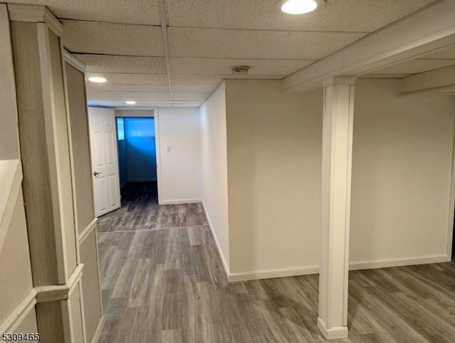 hall featuring a drop ceiling and hardwood / wood-style floors