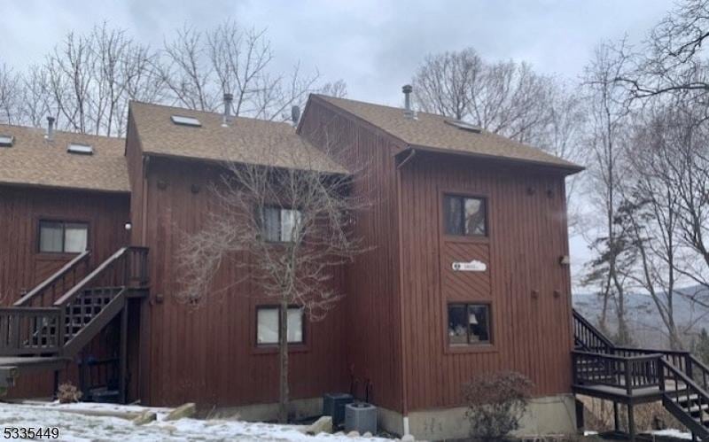 snow covered property featuring central AC unit