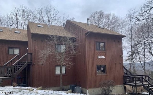 snow covered property featuring central AC unit