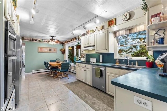 kitchen featuring dishwasher, dark countertops, a baseboard radiator, open shelves, and a sink