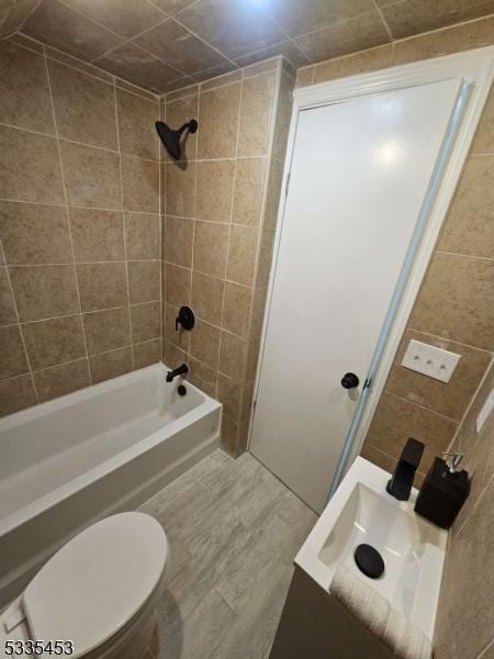 full bathroom with toilet, tiled shower / bath combo, and sink