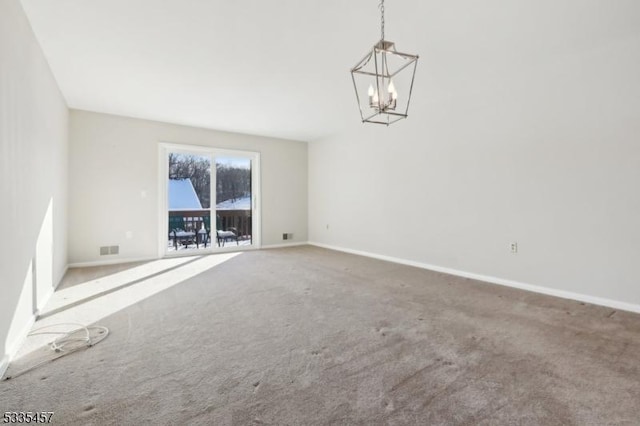 carpeted empty room featuring a notable chandelier