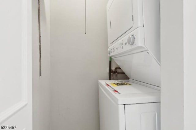 clothes washing area with stacked washer and clothes dryer