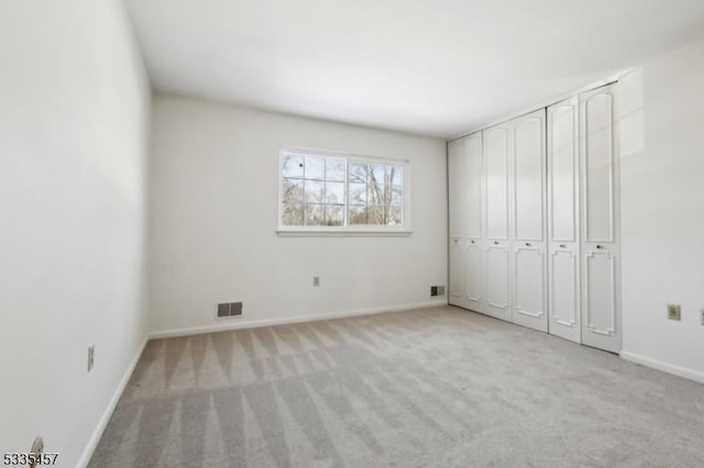 unfurnished bedroom featuring light carpet