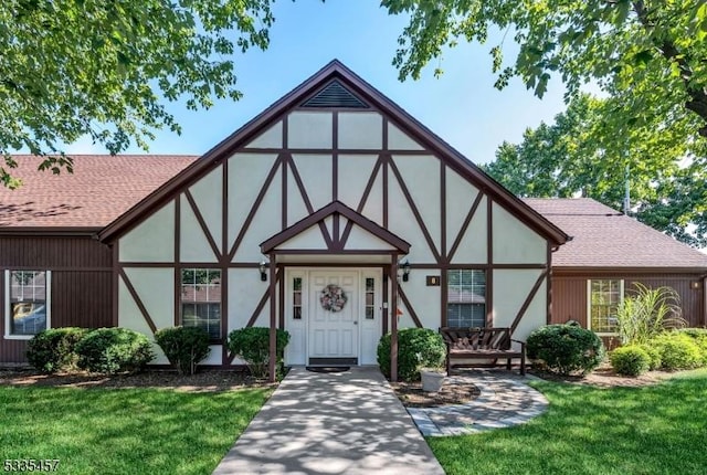 tudor-style house featuring a front lawn