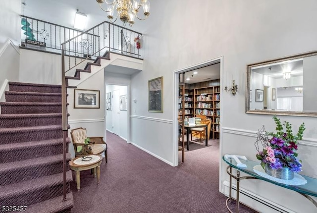 interior space with baseboard heating, a towering ceiling, and a chandelier