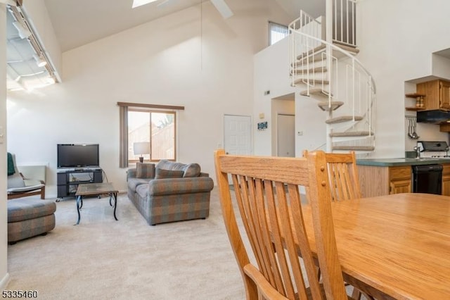 carpeted dining room with a wealth of natural light, high vaulted ceiling, and a skylight