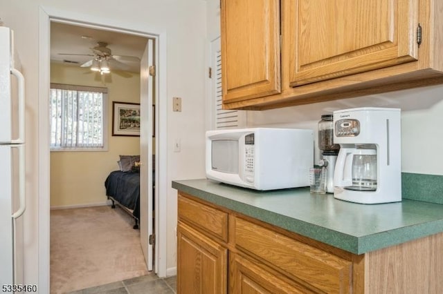 kitchen featuring ceiling fan, light carpet, and white appliances