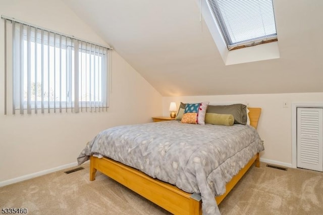 carpeted bedroom with lofted ceiling with skylight