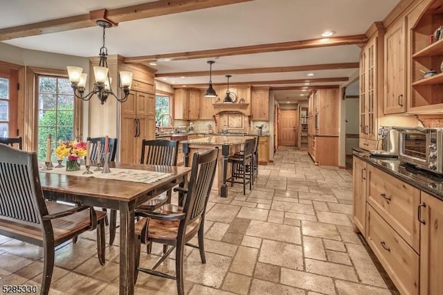 dining area with beamed ceiling, plenty of natural light, and a notable chandelier