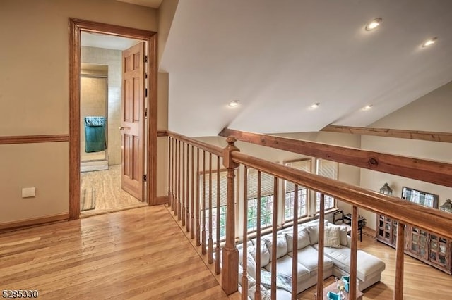 corridor with lofted ceiling and light hardwood / wood-style floors