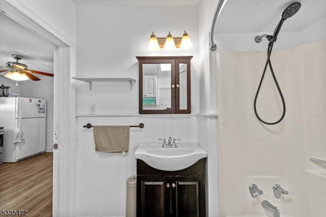 bathroom with vanity, hardwood / wood-style flooring, and shower / washtub combination