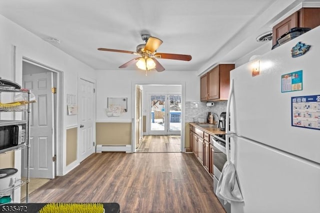 kitchen featuring sink, a baseboard radiator, appliances with stainless steel finishes, dark hardwood / wood-style floors, and decorative backsplash