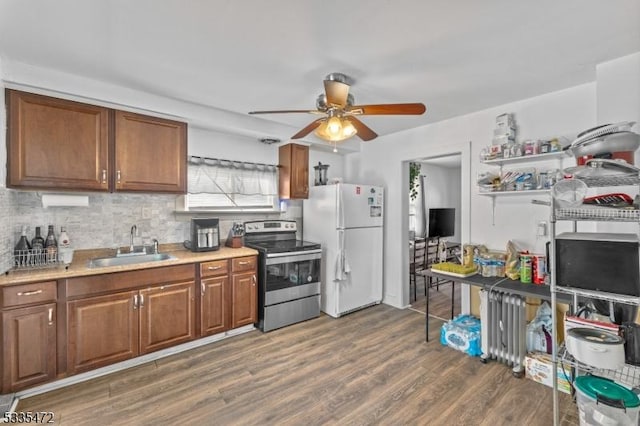 kitchen featuring stainless steel electric stove, dark hardwood / wood-style floors, sink, decorative backsplash, and white refrigerator