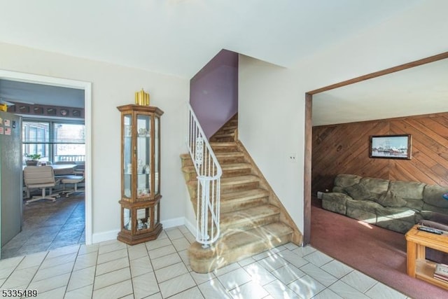 stairs featuring wooden walls and tile patterned floors