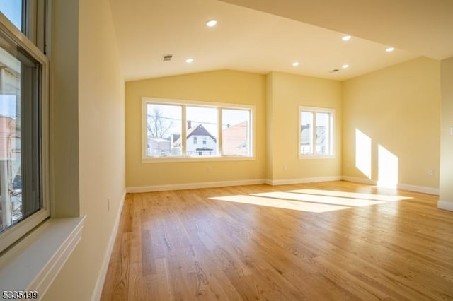 additional living space featuring vaulted ceiling and light hardwood / wood-style flooring