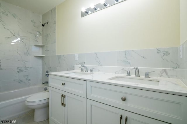 full bathroom with tile walls, vanity, tiled shower / bath, and toilet