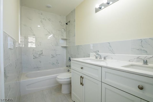 full bathroom featuring vanity, toilet, tiled shower / bath combo, and tile walls