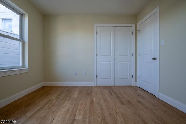 unfurnished bedroom featuring a closet and light hardwood / wood-style flooring