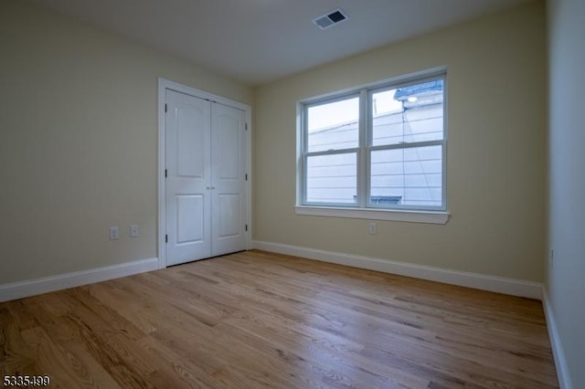 unfurnished bedroom featuring a closet and light wood-type flooring