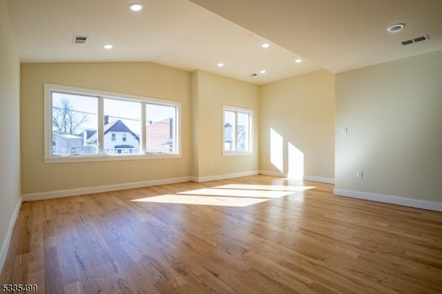 additional living space featuring vaulted ceiling and light wood-type flooring