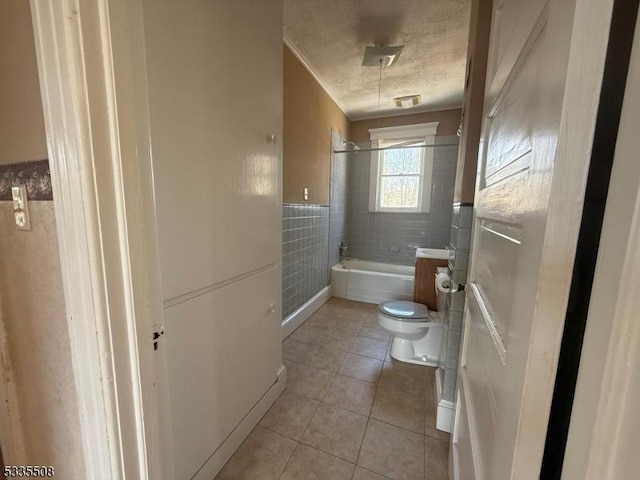 full bathroom featuring tile walls, tiled shower / bath combo, a textured ceiling, tile patterned floors, and toilet