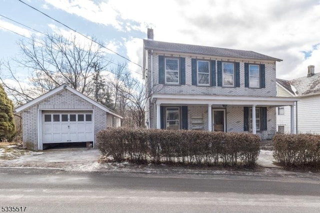 view of front of home featuring covered porch, a garage, and an outbuilding