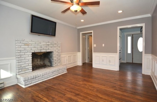 unfurnished living room with crown molding, a fireplace, dark hardwood / wood-style floors, and ceiling fan