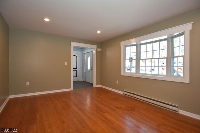 spare room with a baseboard radiator and wood-type flooring