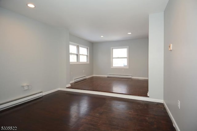 spare room with a baseboard heating unit and hardwood / wood-style floors