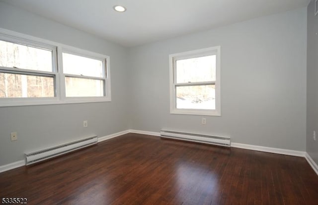 empty room featuring a baseboard radiator and dark hardwood / wood-style floors