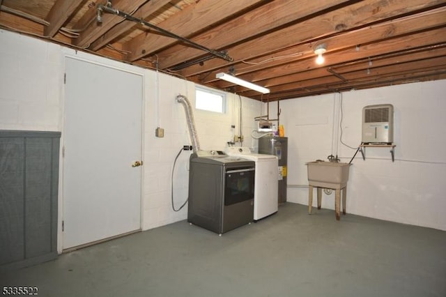 basement featuring electric water heater and washing machine and clothes dryer