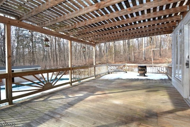 snow covered deck featuring a pergola and an outdoor fire pit