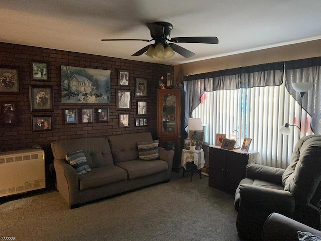 carpeted living room with radiator heating unit, ceiling fan, and brick wall