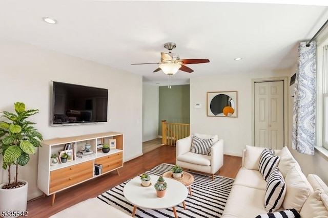 living room with dark hardwood / wood-style flooring and ceiling fan