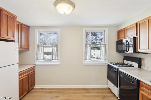 kitchen featuring light wood-type flooring and black appliances