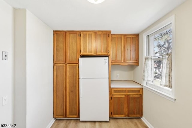 kitchen featuring light hardwood / wood-style flooring and white fridge