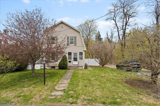 view of front of home featuring fence, a gambrel roof, and a front yard