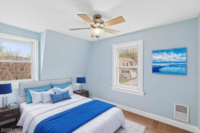 bedroom with visible vents, baseboards, and ceiling fan