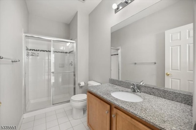 bathroom featuring walk in shower, vanity, toilet, and tile patterned flooring