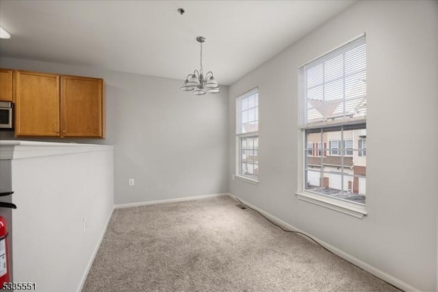 dining space with an inviting chandelier and light colored carpet