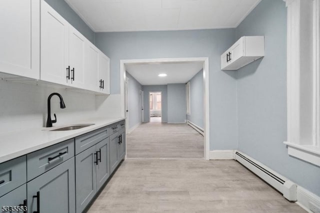 kitchen with gray cabinets, a baseboard radiator, sink, and white cabinets