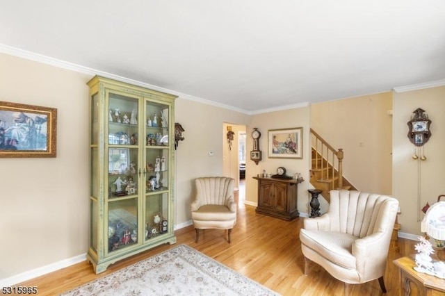 living area featuring ornamental molding and light wood-type flooring