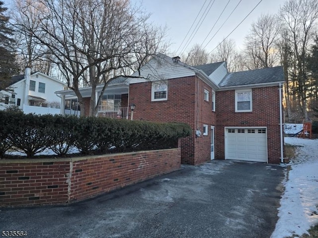 snow covered property with a garage